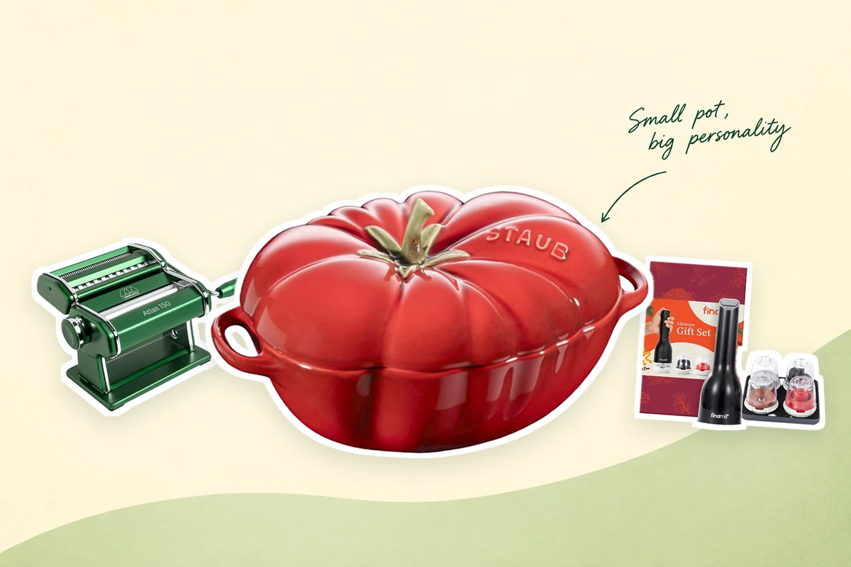 A red tomato-shaped STAUB cocotte at the center, with a green MARCATO pasta machine and FinaMill gift set on a cream and green background and a handwritten Small pot, big personality note