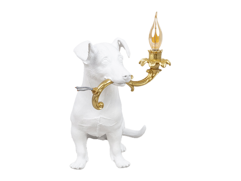 A white Seletti Rio dog lamp holding a gold candelabra in its mouth