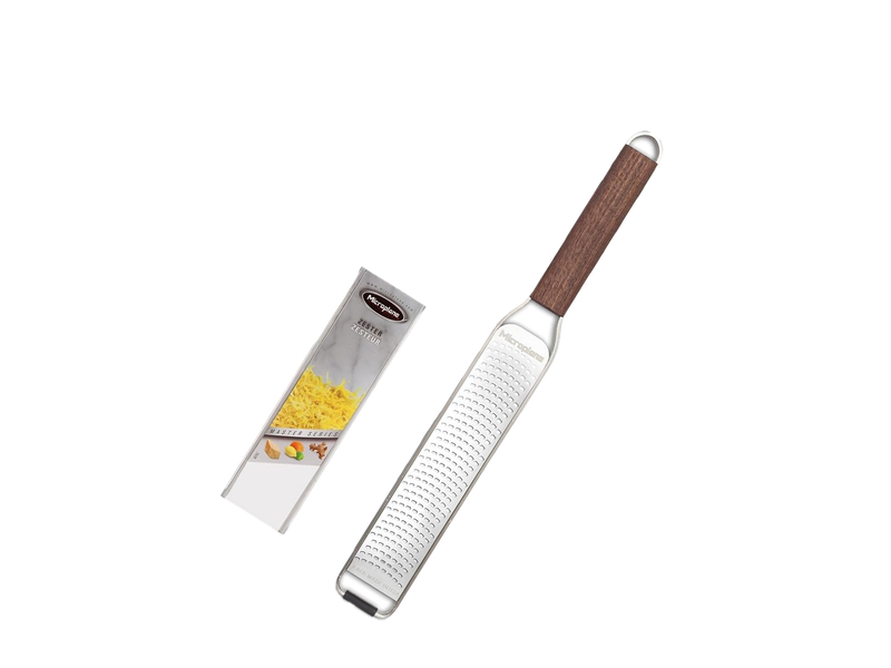A Microplane Master Series stainless-steel zester with a brown walnut handle beside its branded packaging