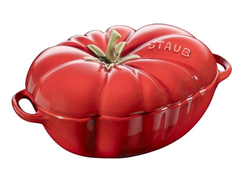 A glossy red STAUB ceramic tomato cocotte with a green stalk on the lid and two small handles