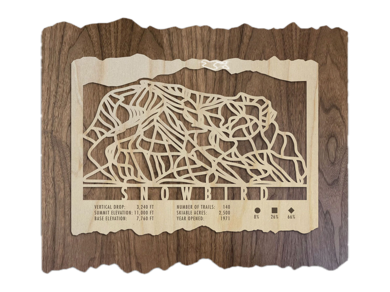 A Mountaincut Snowbird ski trail map in pale birch and darker walnut wood, with the resort name and trail network cut into the layered design